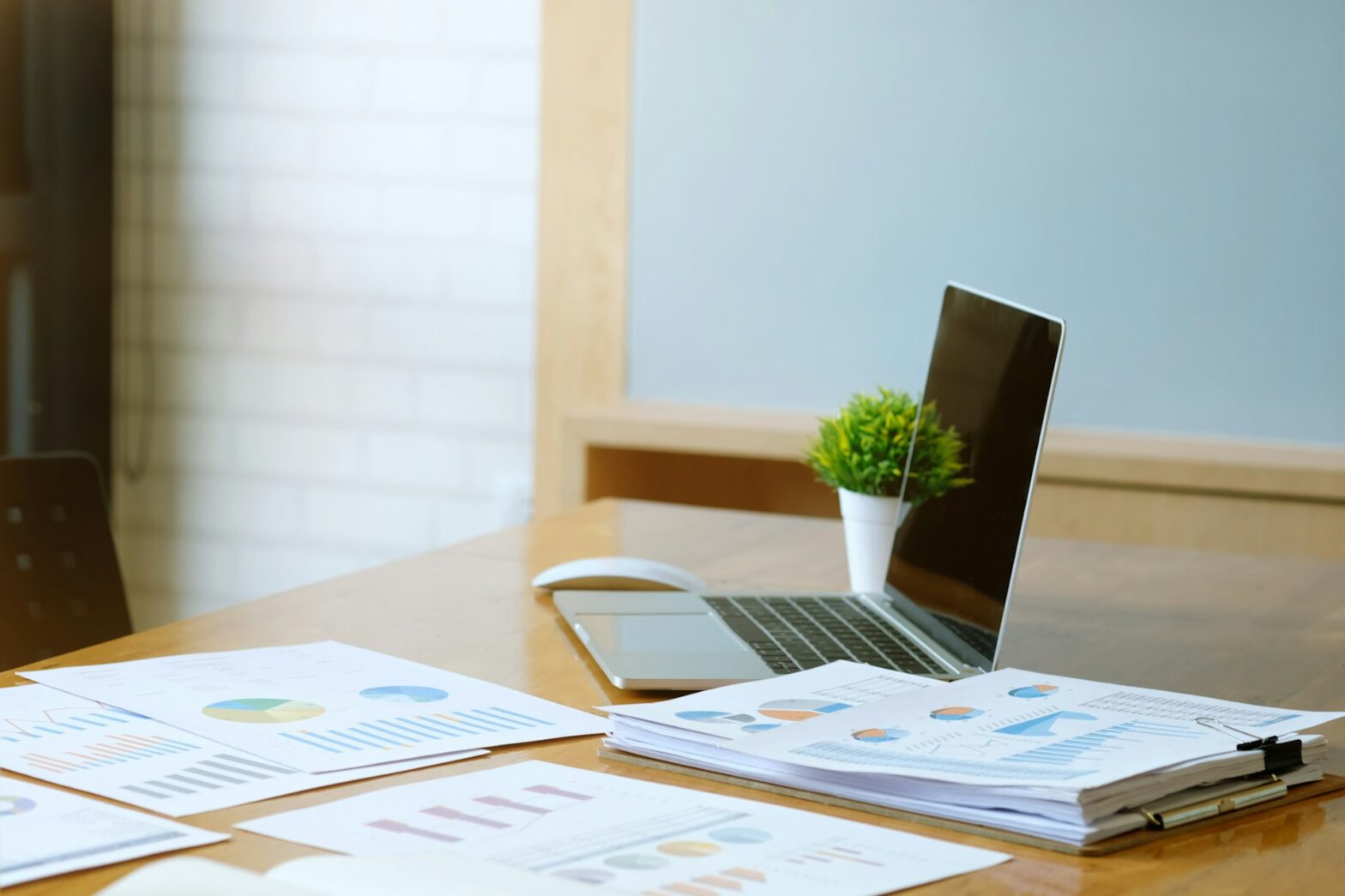 A couple of papers and a laptop on a table